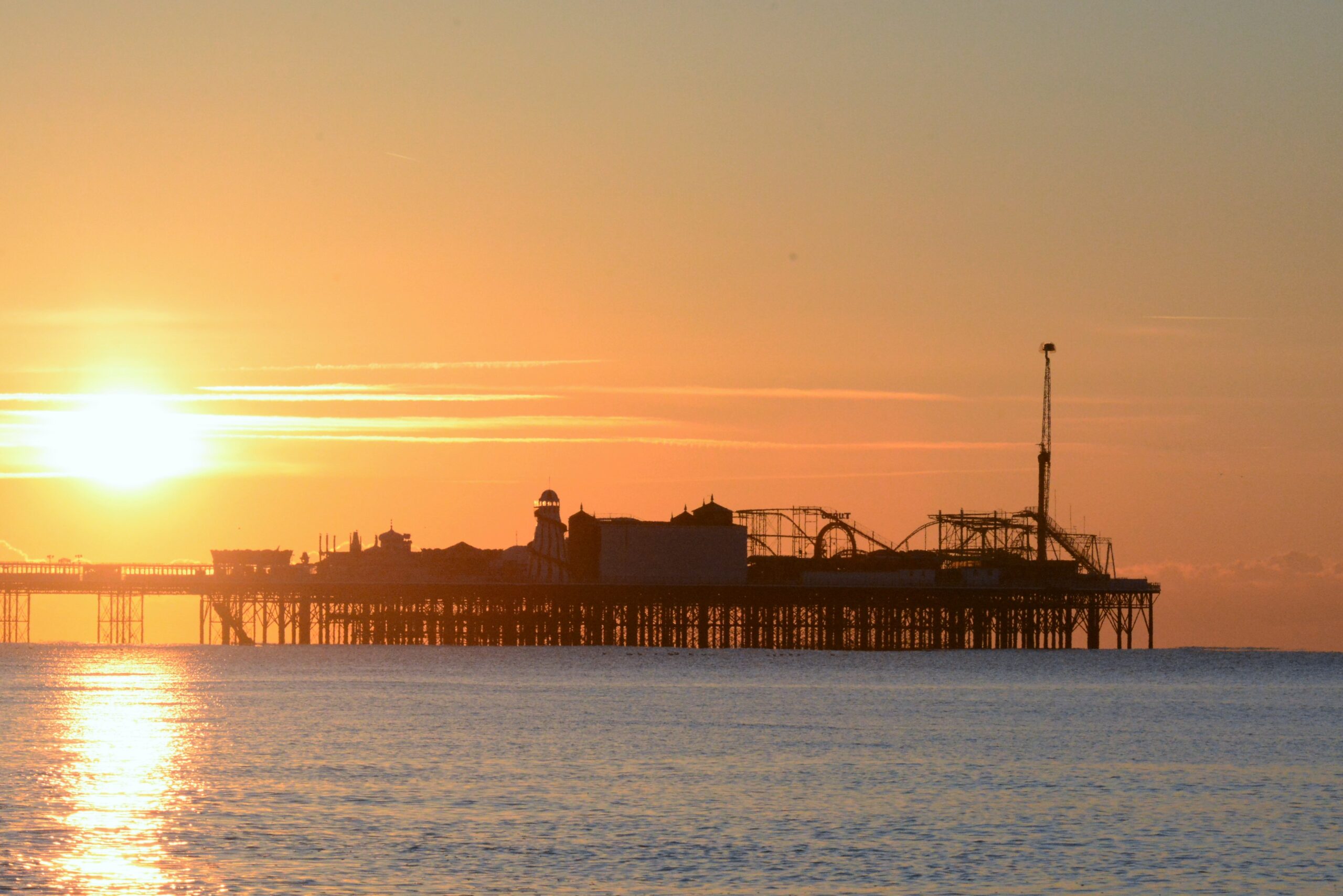 Brighton Palace Pier in golden light across calm sea